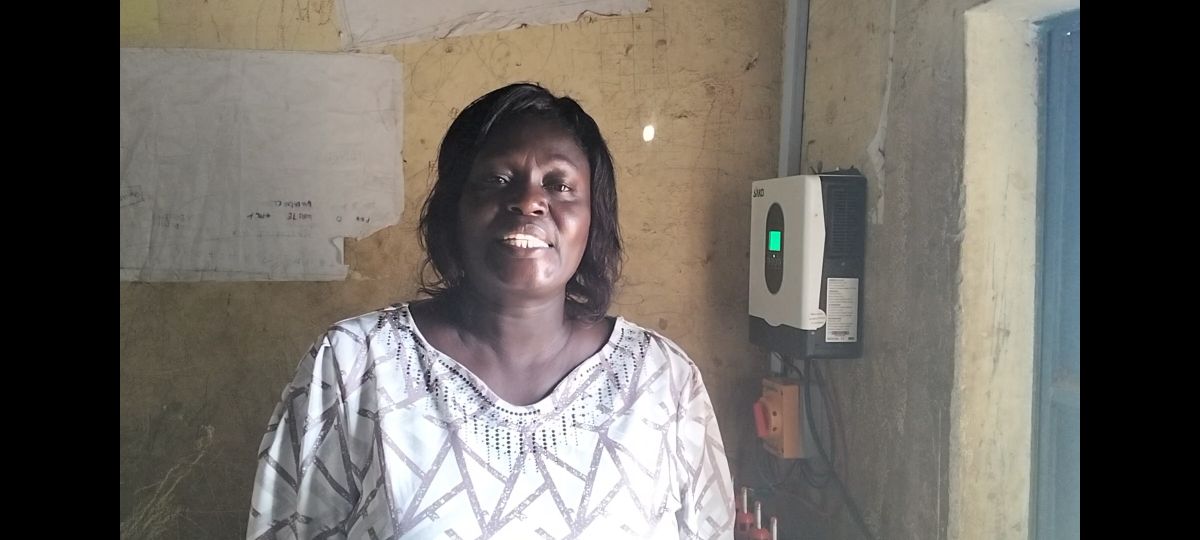 The Head Teacher Ngelechom infront of the hybrid solar system